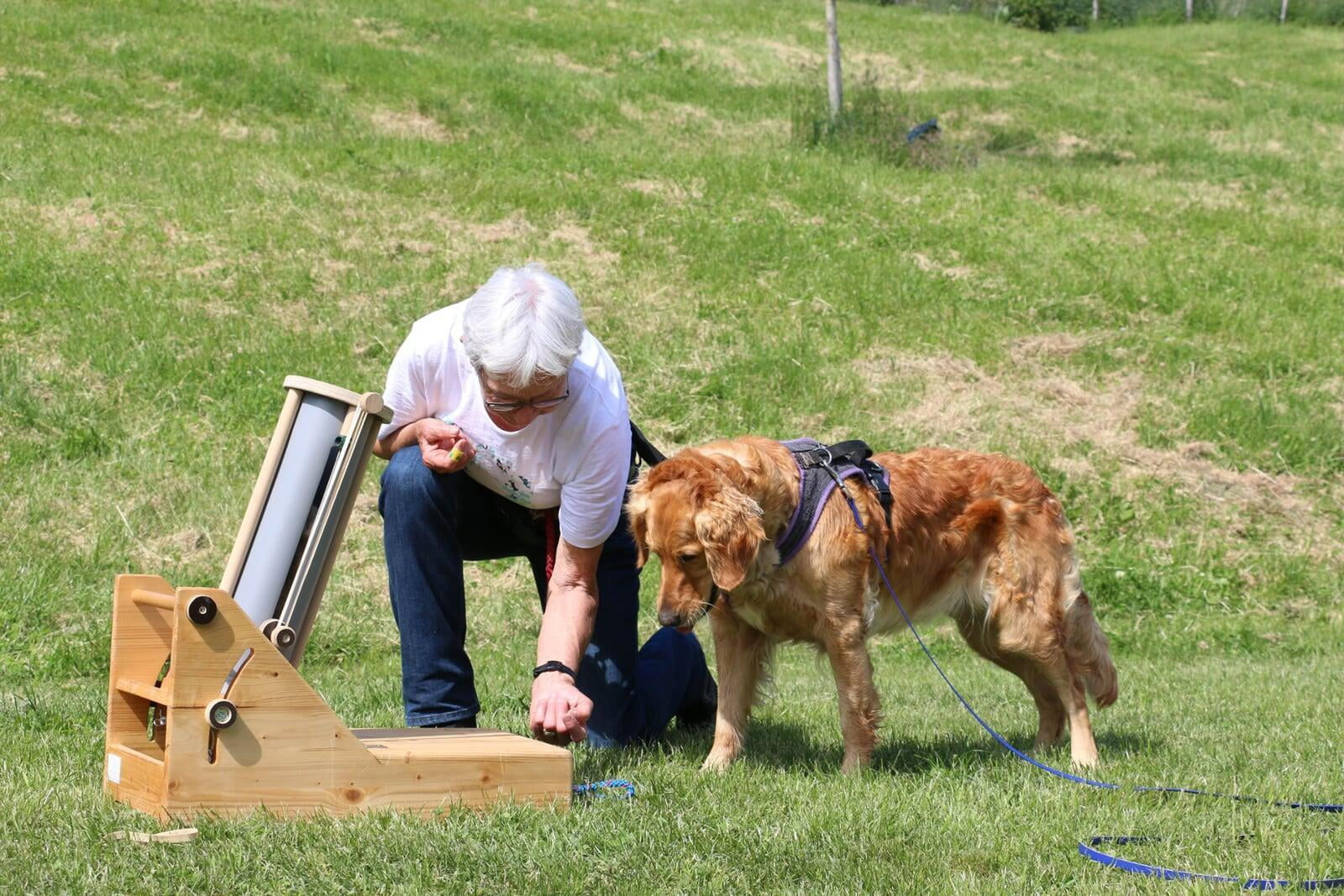 Frau erklärt Hund die Apportierspiel Rohrschleuder